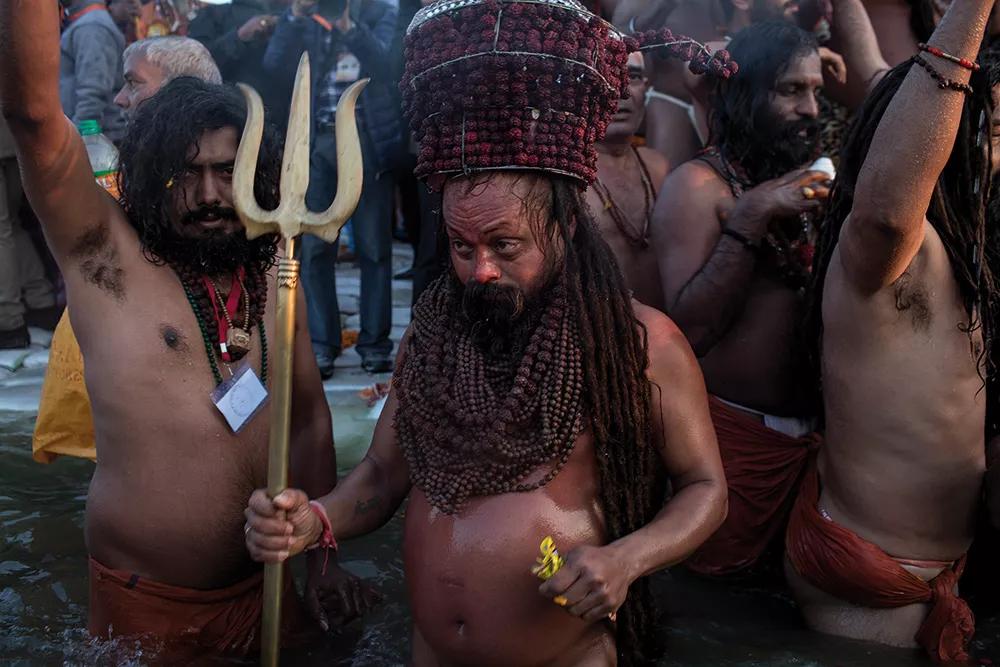 Un sadhu tiene un tridente, símbolo de los devotos de Shiva, durante un baño en el río.
