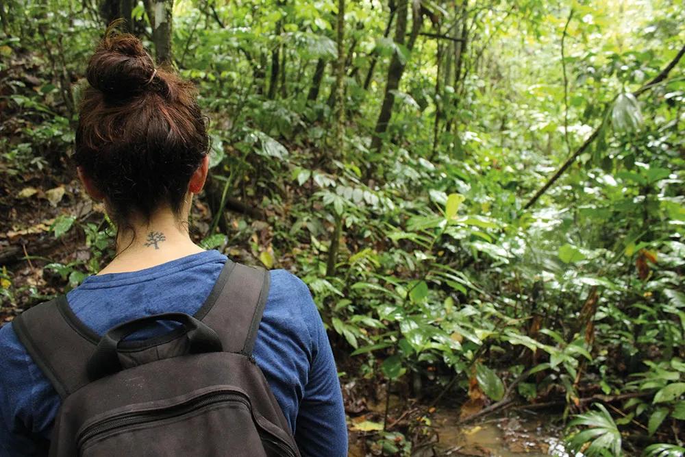 Cristina avanza por la selva, en su nuca la estampa de un árbol tatuada.