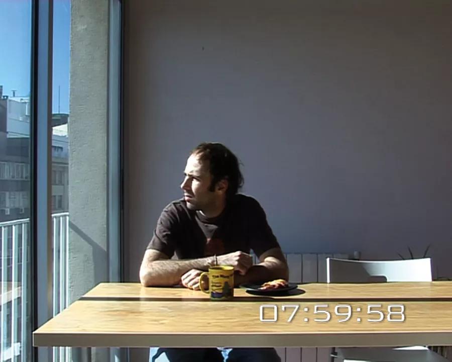 Captura de la video instalación Sobre perder el tiempo (2007) de Raquel Friera. Se contrata a un actor para que “pierda el tiempo” durante ocho horas –el mismo intervalo de una jornada laboral en España–, lo que se entiende por “perder el tiempo” según los resultados obtenidos en una investigación realizada previamente entre los ciudadanos de Barcelona.