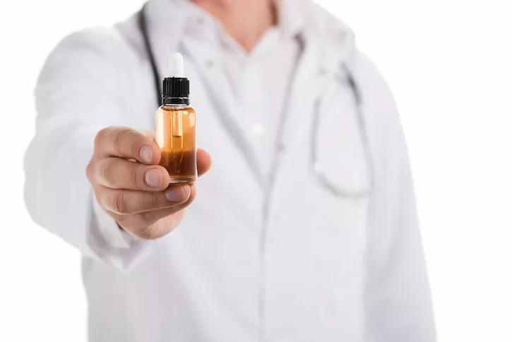 Médico mostrando un pequeño recipiente