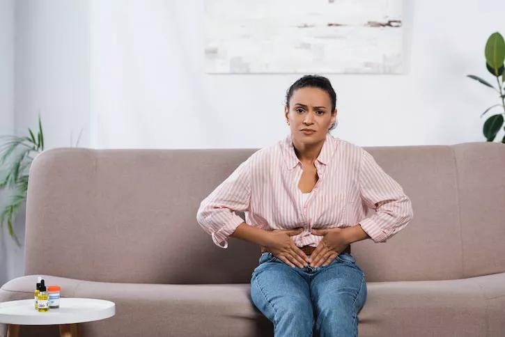 Mujer sentada con dolor en la zona abdominal