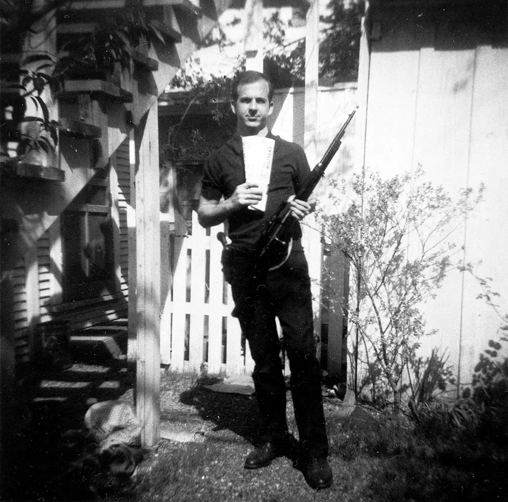 Lee Harvey Oswald posando con su rifle.
